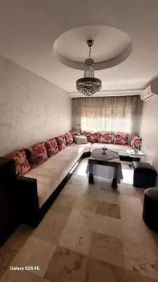 a living room with a long couch and a table at LE 44 face a la gare CTM et a 10mn de L'aéroport in Marrakech
