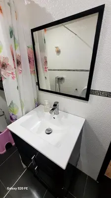 a bathroom with a white sink and a mirror at LE 44 face a la gare CTM et a 10mn de L'aéroport in Marrakech
