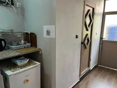 a small kitchen with a door and a refrigerator at Studio Rmila 1 in Marrakech