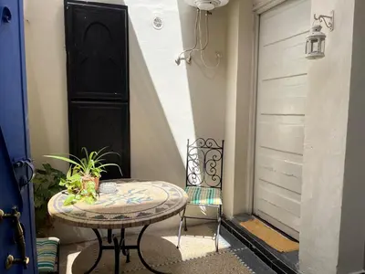 a table and a chair sitting next to a door at Studio Rmila 1 in Marrakech