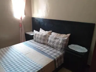 a bedroom with a bed with a black headboard and pillows at Studio Rmila 1 in Marrakech