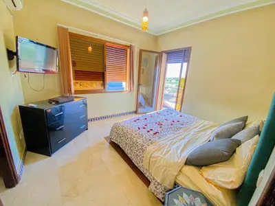 a bedroom with a bed and a dresser and a television at Amlkis golf royal in Marrakech