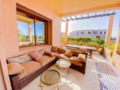 a living room with a couch and a large window at Amlkis golf royal in Marrakech