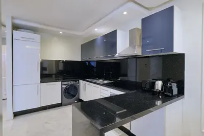 a kitchen with white cabinets and a washer and dryer at Awesome Luxury Apartment in Marrakech in Marrakech