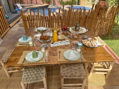 a wooden table with plates of food on it at Villa Riad Jawhar & SPA in Marrakech