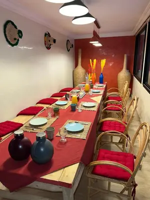 a long table in a room with a red table cloth and chairs at Villa Riad Jawhar & SPA in Marrakech