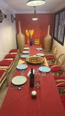 a long table with a red table cloth on it at Villa Riad Jawhar & SPA in Marrakech