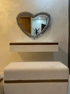a heart shaped mirror on a wall above a bench at Modern Apartment Airport in Marrakech