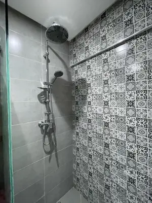a shower in a bathroom with a tile wall at Modern Apartment Airport in Marrakech
