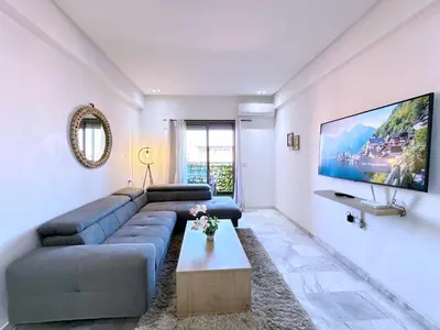 a living room with a couch and a tv on a wall at NEW! appt au cœur de Gueliz ,Terrasse,IPTV,parking in Marrakech