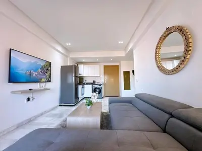 a living room with a large couch and a table at NEW! appt au cœur de Gueliz ,Terrasse,IPTV,parking in Marrakech