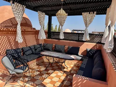 a patio with a couch and a table and chairs at Havre de paix à Atlas Golf Resort Marrakech in Marrakech