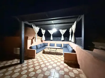a room with a couch and a table and curtains at Havre de paix à Atlas Golf Resort Marrakech in Marrakech
