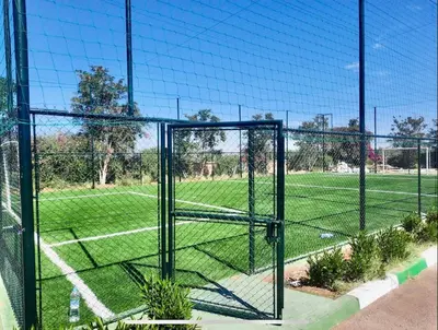 a batting cage with a soccer field behind it at Havre de paix à Atlas Golf Resort Marrakech in Marrakech
