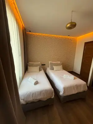 two beds in a room with two windows at Jnane Guéliz 2CH parking wifi Marrakech centre in Marrakech