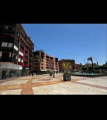 an empty city square with buildings and palm trees at Appartement, Gueliz, WiFi, parking in Marrakech