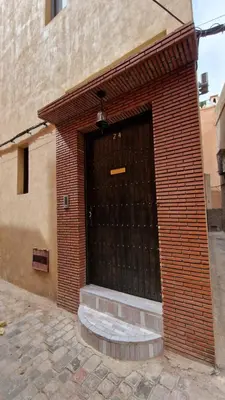 a brick building with a large black door at Riad Dar El Bahja in Marrakech