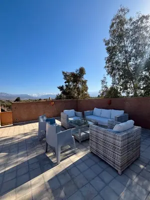 a patio with couches and a table and chairs at NEW Dar Aït Zahra Marrakech-Cook included-View ATLAS in Marrakech