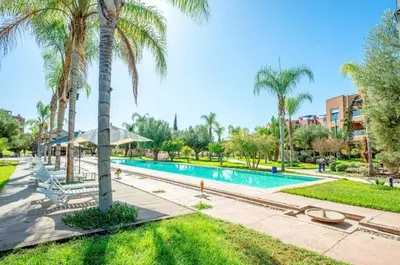 a swimming pool with palm trees in a park at Appartement moderne et chic, avec piscine pour femmes et Parc de jeux in Dar Caïd Layadi