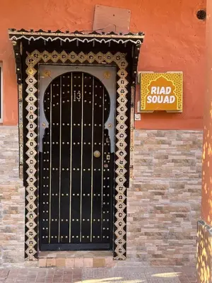 a black door with a sign on the side of a building at Bienvenus dans un beau nouveau Riad Tout Entier pour vous in Marrakech