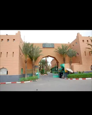 a large building with palm trees in front of it at Bienvenus dans un beau nouveau Riad Tout Entier pour vous in Marrakech