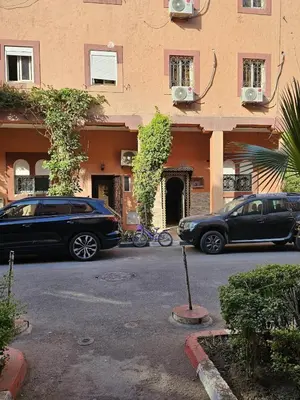 two cars parked in a parking lot in front of a building at Bienvenus dans un beau nouveau Riad Tout Entier pour vous in Marrakech