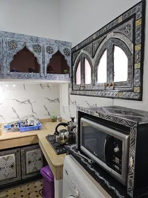 a kitchen with a stove and a microwave at Bienvenus dans un beau nouveau Riad Tout Entier pour vous in Marrakech