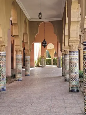 an empty hallway of a building with columns and arches at Bienvenus dans un beau nouveau Riad Tout Entier pour vous in Marrakech