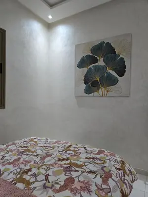 a bedroom with a bed and a painting on the wall at Cozy and spacious apartment in Marrakech in Marrakech
