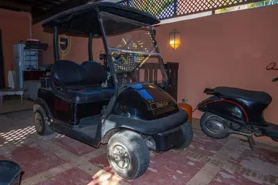 a golf cart parked in a room with a scooter at Amelkis golf villa 3 ch private pool in Marrakech