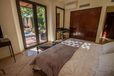 a bedroom with a large bed and a view of a pool at Amelkis golf villa 3 ch private pool in Marrakech