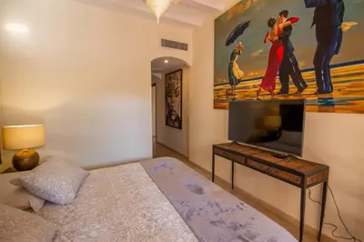 a bedroom with a bed and a painting on the wall at Amelkis golf villa 3 ch private pool in Marrakech