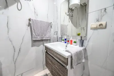 a white bathroom with a sink and a mirror at Élégant avec Parking - Guéliz Hivernage in Marrakech