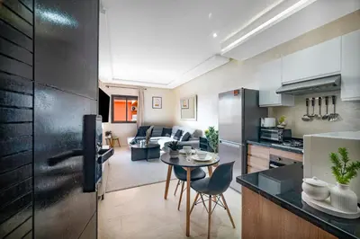 a kitchen and living room with a table and chairs at Élégant avec Parking - Guéliz Hivernage in Marrakech
