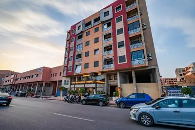 a tall building with cars parked in front of it at Élégant avec Parking - Guéliz Hivernage in Marrakech