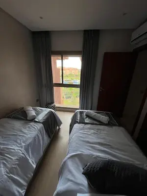 two beds in a room with a window at Appartement de luxe prestigia agate Marrakech in Marrakech