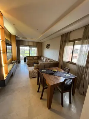 a living room with a table and a couch at Appartement de luxe prestigia agate Marrakech in Marrakech