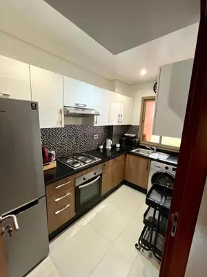 a kitchen with a refrigerator and a stove top oven at Appartement de luxe prestigia agate Marrakech in Marrakech