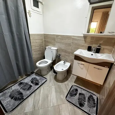 a bathroom with a toilet and a sink with rugs at Spacious apartment in Marrakech in Marrakech