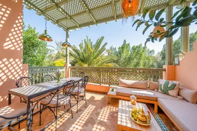 a patio with a table and chairs and a couch at Palm Nest in Marrakech