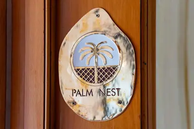 a wooden door with a palm nest sign on it at Palm Nest in Marrakech
