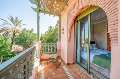 a balcony of a house with a bed and a bedroom at Palm Nest in Marrakech