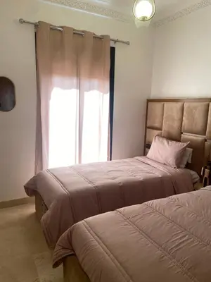 two beds in a room with a window at Luxurious appartement Marrakech - pool&terrace in Marrakech