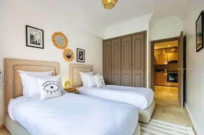 two beds sitting next to each other in a bedroom at Au coeur Hivernage Proche M avenue in Marrakech