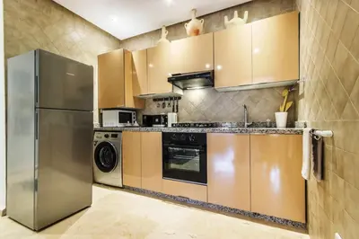 a kitchen with a stainless steel refrigerator and a dishwasher at Au coeur Hivernage Proche M avenue in Marrakech