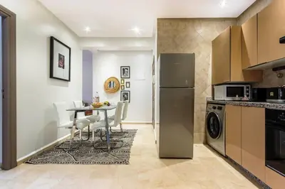a kitchen with a table and a dining room at Au coeur Hivernage Proche M avenue in Marrakech