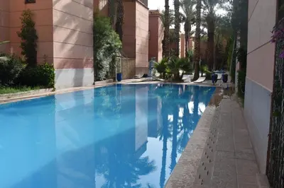 a swimming pool in a building with blue water at Riad Zaitone 134 in Marrakech
