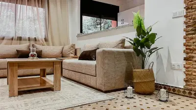 a living room with a couch and a table at Appartement 1ch Hivernage avec Piscine in Marrakech