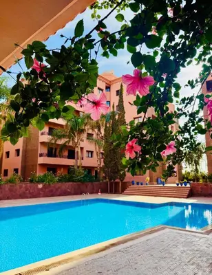 a view of a swimming pool with pink flowers at Appartement 1ch Hivernage avec Piscine in Marrakech