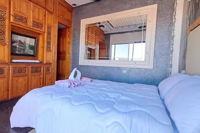 a bedroom with a large bed and a window at Cozy, sunny apartment near the airport in Marrakech